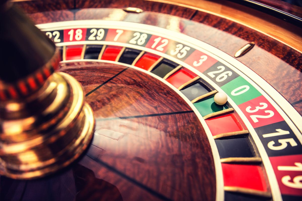 Roulette wheel in casino with ball on green position zero.